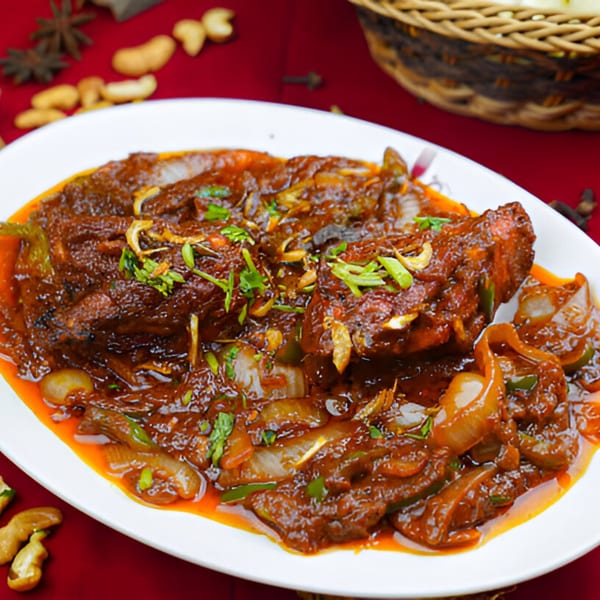 BB's Indian Kitchen's spicy Indian dish with meat, onions, and herbs on a white plate.